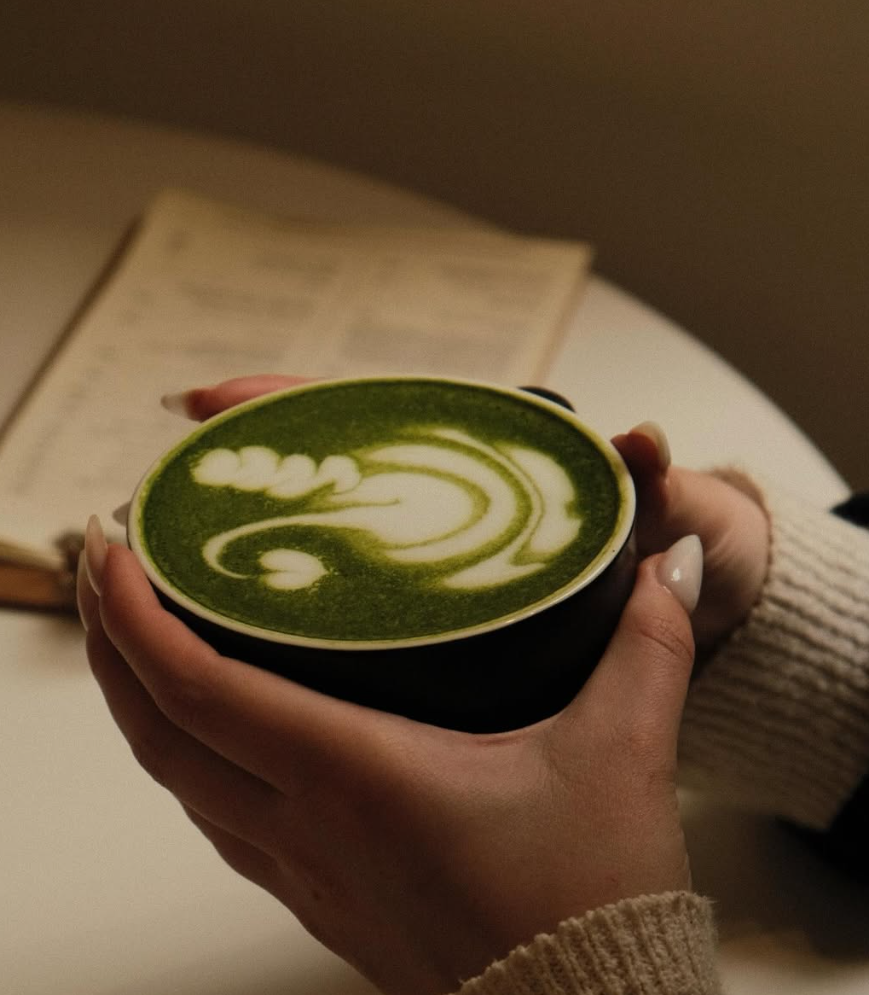 Matcha latte szép latte arttal, kézben tartva